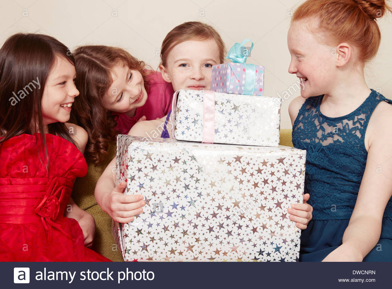 Geburtstagsgeschenk Mädchen
 Mädchen hält Geburtstagsgeschenk mit Freunden Stockfoto